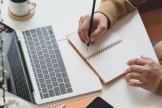 person-writing-on-notebook-next-to-laptop-3787296-scaled-e1588279128675.jpg